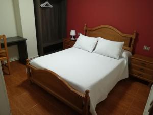 帕拉斯德丽Pensión Restaurante Casa Camiño II的卧室配有一张白色大床和红色墙壁