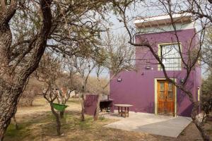 a purple house with a picnic table in front of it at Cabaña Anita in Merlo