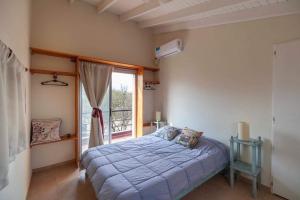 een slaapkamer met een bed en een groot raam bij Cabaña Anita in Merlo