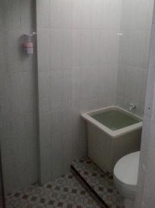 een badkamer met een toilet en een bad bij Balige J&J Guest House 2 in Balige