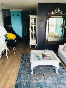 a living room with a coffee table and a mirror at Petit havre de paix in Lancieux