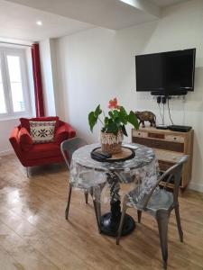 a living room with a table and a tv at U STUDIU 7 rue Notre Dame in Bastia