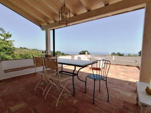 een tafel en stoelen op een patio met uitzicht bij Etna Dependance in Santa Venerina