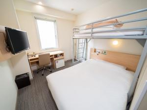 Super Hotel Asakusa في طوكيو: غرفة نوم مع سرير بطابقين ومكتب مع جهاز كمبيوتر