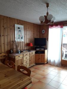 a living room with a television and a dining room table at Le Panda in Les Carroz d'Araches