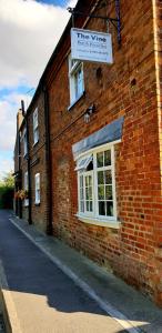 a red brick building with a white sign on it at The Vine B & B in South Thoresby