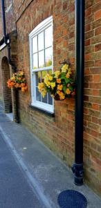 a window with flowers on the side of a brick building at The Vine B & B in South Thoresby