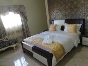 ein Schlafzimmer mit einem großen Bett mit zwei Handtüchern darauf in der Unterkunft Hotel Golden House in Diego Suarez