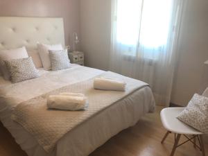 a bedroom with a large bed with two towels on it at Apartamentos Logroño centro, TIC TAC, wifi in Logroño