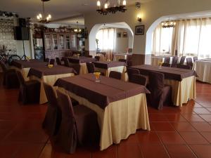 Alojamento Ar e Sol في غيمارايش: قاعة احتفالات مع طاولات وكراسي في غرفة