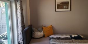 a room with a couch with pillows and a window at Dorfstraße 21 Ferienwohnung 3 in Schwielowsee