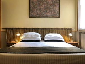 a bedroom with a large bed with two pillows at Hotel Villa Belvedere in Bonassola