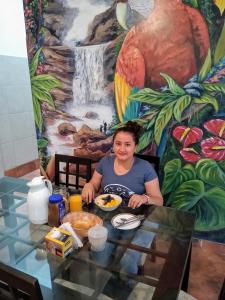 Monteverde Tarapoto "Eco-Friendly" في تارابوتو: امرأة تجلس على طاولة مع طبق من الطعام