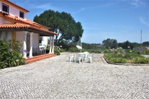 a patio with a table and chairs in front of a house at Vagos Art.Lab in Vagos