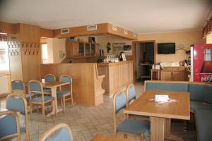 ein Restaurant mit Tischen und Stühlen und eine Küche in der Unterkunft Gästehaus Kaiserkrone in Schöna