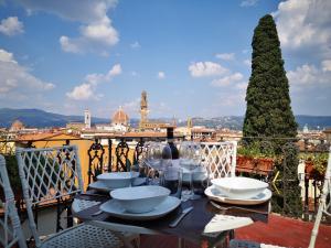 a table with plates and wine glasses on a balcony at The View Of Sangiorgio in Florence