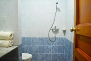 a bathroom with a shower with a toilet at Super OYO 1240 Hotel Pantai Jaya in Pangandaran