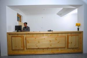 a man sitting at a desk with a computer at Hunder Residency in Leh