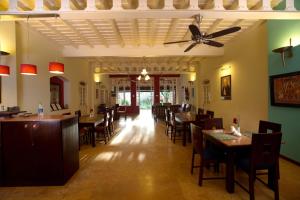 uma sala de jantar com mesas e cadeiras e uma ventoinha de tecto em Tea Bungalow em Cochin