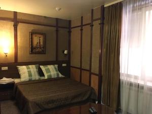 a bedroom with a bed and a window at Hotel Aura in Rostov on Don