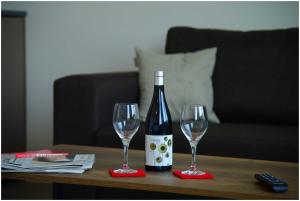 a bottle of wine and two wine glasses on a table at Motel Plus Schönefeld in Schönefeld