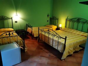 two beds in a room with green walls at Agriturismo Il Pozzo Antico in Mascali