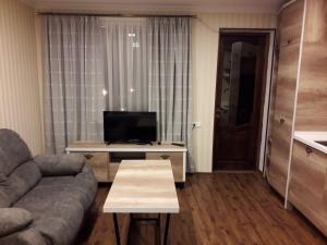 a living room with a couch and a tv and a table at Apartment borjomi, Erekle street, 21A in Borjomi