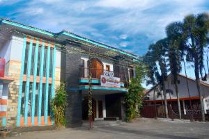 a building on a street with trees in front of it at Super OYO 1240 Hotel Pantai Jaya in Pangandaran