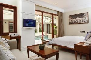 a bedroom with a bed and a living room at Seminyak Lagoon All Suites Hotel in Seminyak