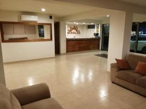 ein Wohnzimmer mit 2 Sofas und einer Küche in der Unterkunft Misol-Ha Hotel Mérida in Mérida