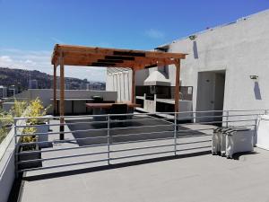 una terraza en la azotea con una mesa y una pérgola en Apartamento Boulevard Poniente, en Viña del Mar