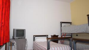 Zimmer mit 2 Etagenbetten und einem TV in der Unterkunft Residence Praetorium Maiella in Pretoro