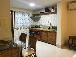 a kitchen with a glass table and a counter top at Pipa Flat Solar in Pipa