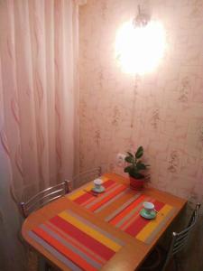 a dining room table with a striped table and chairs at "Ботанический сад" Тихий район Квартира in Almaty