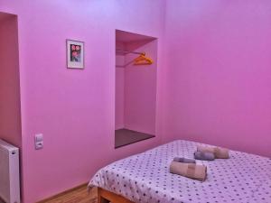 een slaapkamer met paarse muren en een bed met kussens bij Vercxli 24 in Tbilisi City