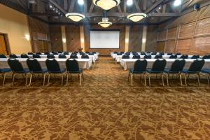una sala conferenze con tavoli, sedie e schermo di Kentucky Dam Village State Resort Park a Gilbertsville