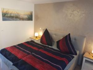 a bedroom with a bed with red and black pillows at Apartment Claudia in Sinsheim