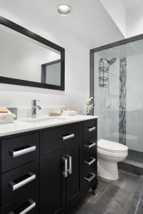 a bathroom with a sink and a toilet and a mirror at Vine Village Apartments in Niagara on the Lake