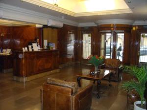 Eine Lobby mit einer Frau an einem Schreibtisch in einem Gebäude in der Unterkunft Hotel Lyon by MH in Buenos Aires