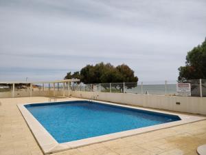 a swimming pool with the ocean in the background at Oceanides Beachfront Apartments in Quarteira