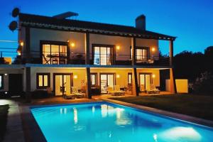 a villa with a swimming pool in front of a house at Monte das Matas in Monsaraz