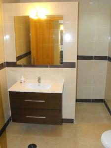 a bathroom with a sink and a mirror and a toilet at Monte das Matas in Monsaraz