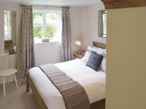 A bed or beds in a room at Gardeners Cottage 