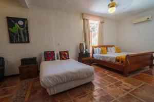 a bedroom with two beds and a window at Casa de los Sueños Hotel Boutique in Isla Mujeres