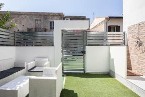 an outdoor patio with a fence and grass at Sea Elegance in Oliveri