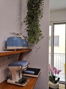 a blue mixer sitting on a shelf next to a window at MARGHERITA BOUTIQUE ROOMS in Margherita di Savoia