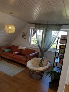 ein Wohnzimmer mit einem Sofa und einem Stuhl in der Unterkunft Schöne, helle FeWo für 4 Personen in Ettenheim