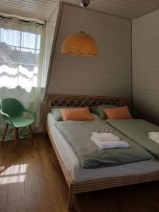 1 dormitorio con 2 camas y silla verde en Schöne, helle FeWo für 4 Personen en Ettenheim