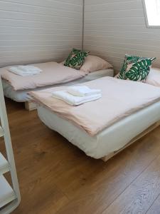 two twin beds in a room with wood floors at Schöne, helle FeWo für 4 Personen in Ettenheim