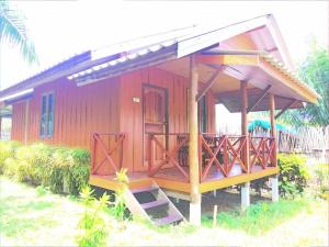 a small red house with a porch and a balcony at YaoIsland Resort and Farm in Ko Yao Yai
